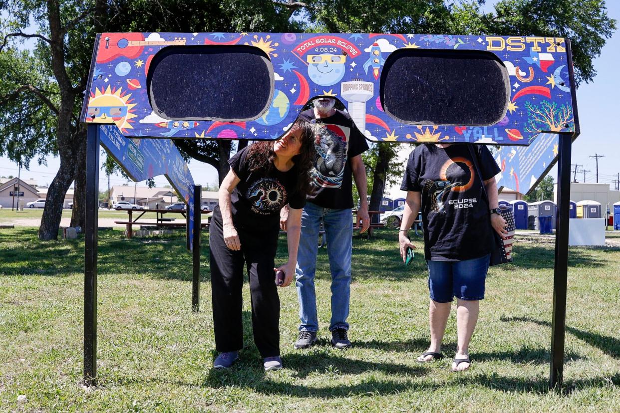 <span>A family looks through a pair of giant solar eclipse glasses at Veterans Memorial Park in Dripping Springs, Texas, on Thursday.</span><span>Photograph: Adam Davis/EPA</span>