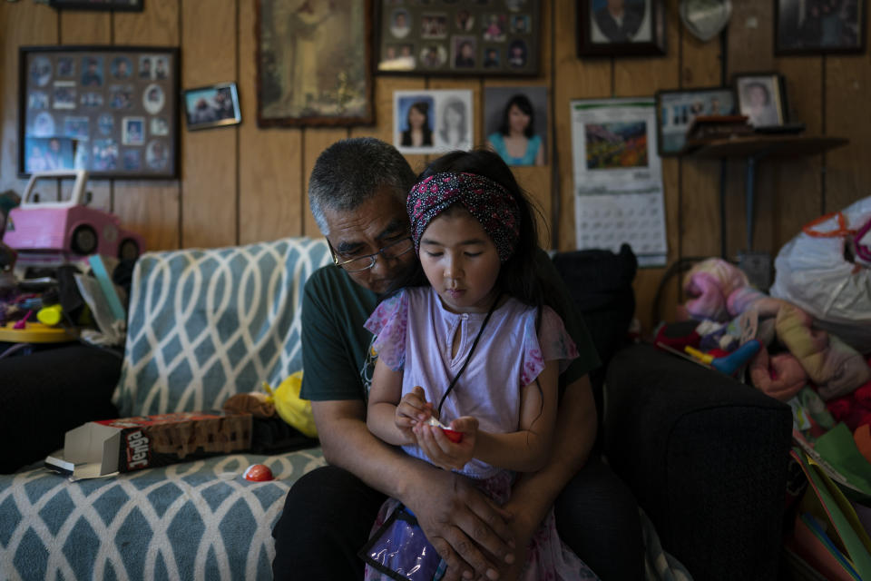 Alfred Ningeulook, 61, hugs his granddaughter, Glenna, 6, in his home in Shishmaref, Alaska, Sunday, Oct. 2, 2022. Rising sea levels, flooding, increased erosion and loss of protective sea ice and land have led residents of this island community to vote twice to relocate. But more than six years after the last vote, Shishmaref remains in the same place because the relocation is too costly. (AP Photo/Jae C. Hong)