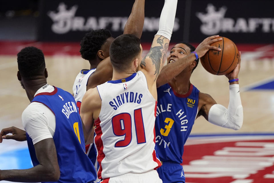 Denver Nuggets guard Shaquille Harrison (3) is defended by Detroit Pistons guard Deividas Sirvydis (91) and guard Saben Lee during the first half of an NBA basketball game, Friday, May 14, 2021, in Detroit. (AP Photo/Carlos Osorio)