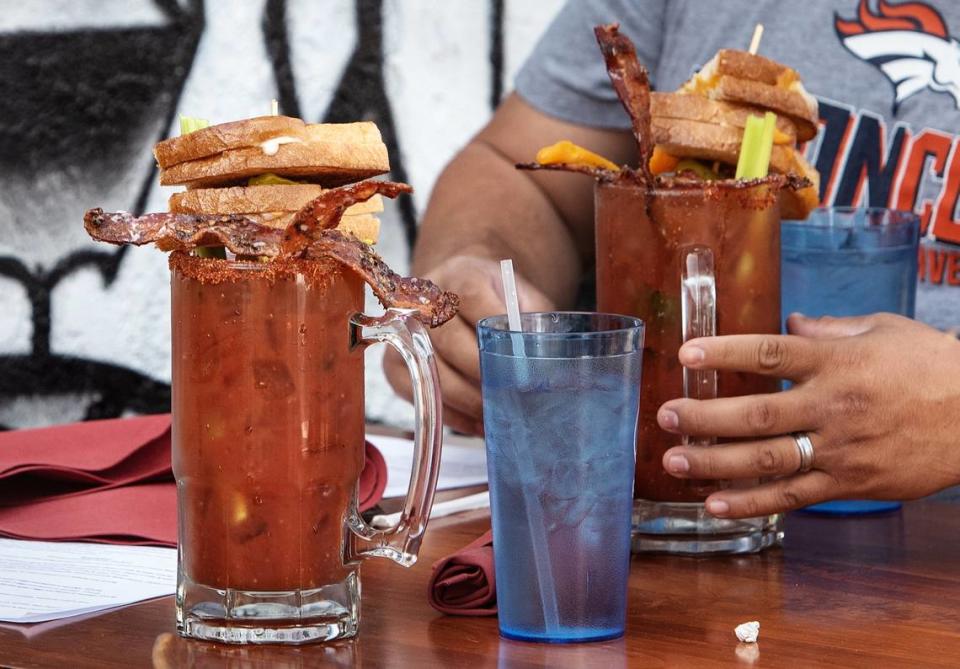 Customers enjoy a bloody mary garnished with a grilled cheese sandwich at Harvest Moon restaurant in Modesto, Calif., on Friday, Oct. 16, 2020.