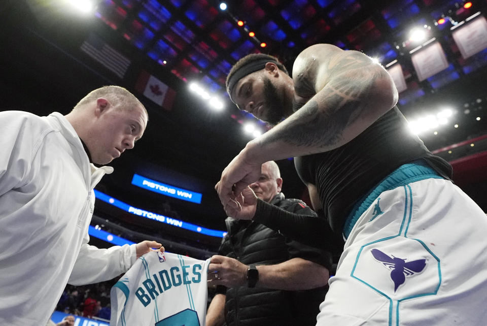 Charlotte Hornets forward Miles Bridges (0) gives his jersey to a fan after the second half of an NBA basketball game against the Detroit Pistons, Monday, March 11, 2024, in Detroit. (AP Photo/Carlos Osorio)