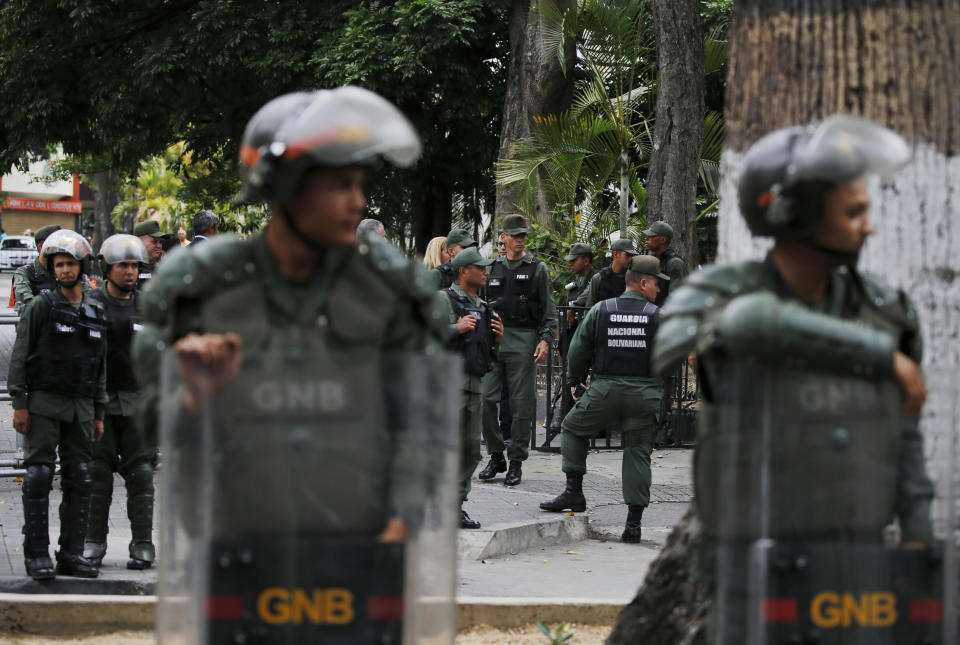 Venezuelan Bolivarian National stand guard around the National Assembly building as the opposition-controlled congress met to discuss a move could provide political cover for greater international involvement in the nation's crisis, in Caracas, Venezuela, Tuesday, May 7, 2019. Military police prevented journalists from entering the National Assembly, and some reporters were harassed by government supporters outside the building. (AP Photo/Fernando Llano)