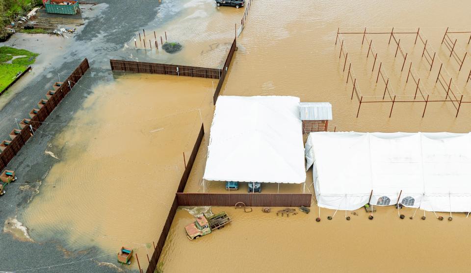 This aerial photograph shows vehicles and farm equipment flooded at the Mickelson Pumpkin Patch in Petaluma, California, on February 4, 2024. The US West Coast was getting drenched on February 1 as the first of two powerful storms moved in, part of a "Pineapple Express" weather pattern that was washing out roads and sparking flood warnings. The National Weather Service said "the largest storm of the season" would likely begin on February 4.