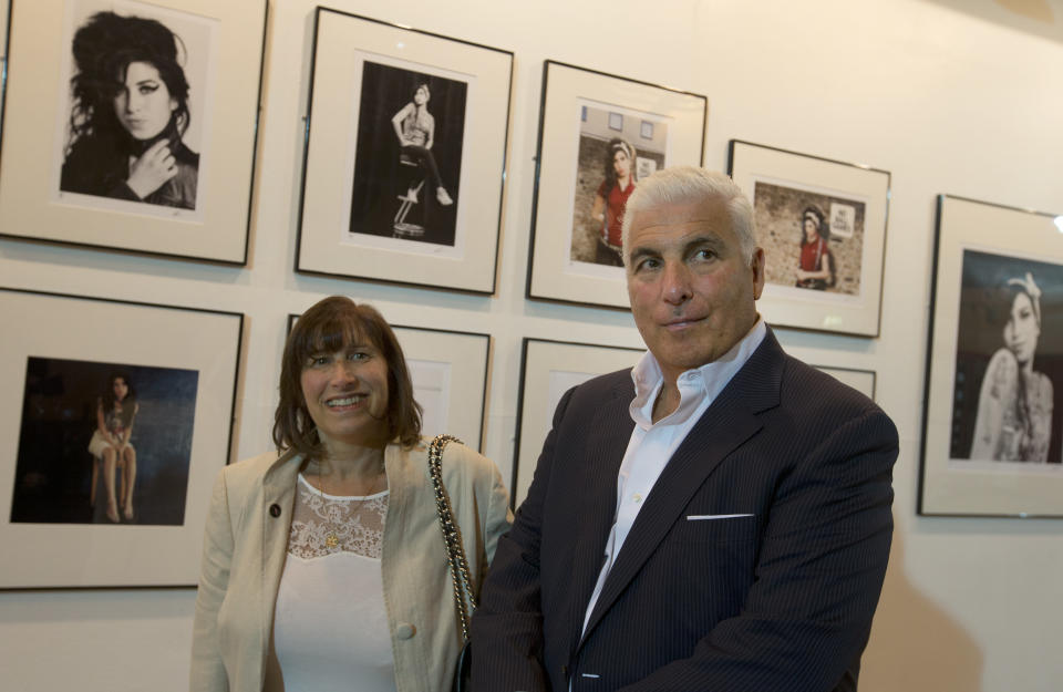 Janice and Mitch Winehouse mother and father of the late British singer Amy pose for the media, in front of portraits of their daughter at the Proud gallery in Camden, London, Wednesday, Sept.11, 2013. In the month she would have turned 30, Amy Winehouse is being celebrated in Camden the London neighbourhood that was her physical and spiritual home, she died of accidental alcohol poisoning at her house in July 2011, aged 27. The neighbourhood still attracts her fans, and local officials and businesses are holding a series of September events to raise money for the Amy Winehouse Foundation, a youth charity established by the singer's family. (AP Photo/Alastair Grant)