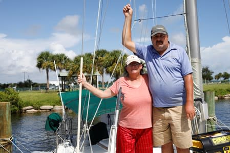 Lisa and Ned Keahey, who live in a sailboat and plan to stay aboard during Hurricane Dorian, pose for a photo at a marina in Titusville