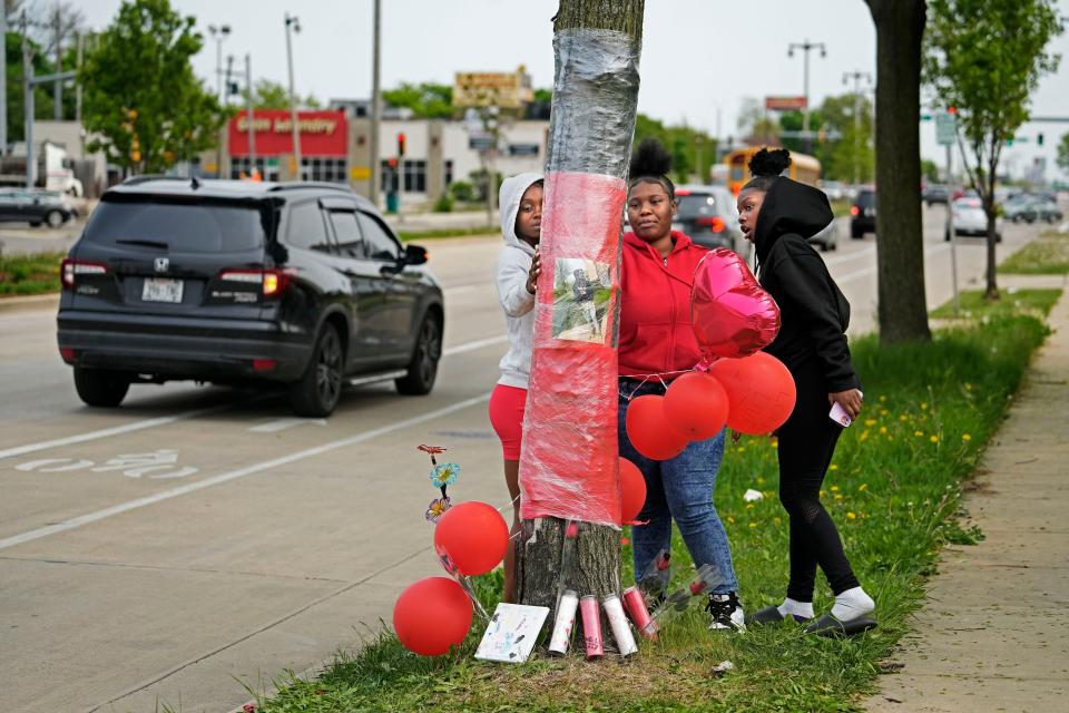 Friends of Isreal Williams who was among the five people killed in Sunday's accident on West Fond du Lac Avenue, from left, Jaeosha Nicholson, Jalisa Davis, center and Shantasia Anderson, right, visit a memorial in his honor  near the accident scene on Thursday, May 18, 2023. This area is among 14 intersections in Milwaukee that have seen the most car accidents in a year.