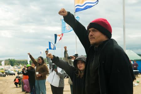 Protestors raise their fists in solidarity with a group from the Saginaw Chippewa Reservation in Mount Pleasant, Michigan as they enter an encampment. REUTERS/Andrew Cullen
