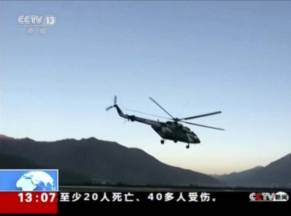 In this image taken from video footage run on Thursday, Oct 18, 2018 by China's CCTV via AP Video, a military helicopter deploys after a landslide formed a barrier lake on Yarlung Tsangpo in Tibet in western China. Thousands of people have been evacuated following a landslide in Tibet that blocked the flow of one of the region's key rivers, China's emergency services said Thursday. (CCTV via AP Video)