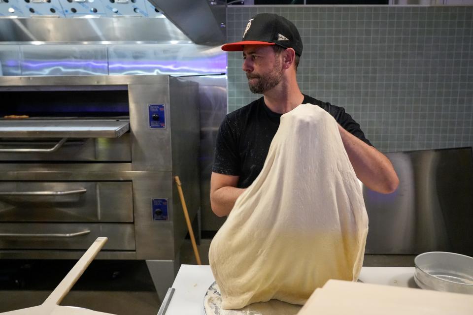 Trophy Pizza co-owner James Moore tosses fresh dough at Trophy Pizza.