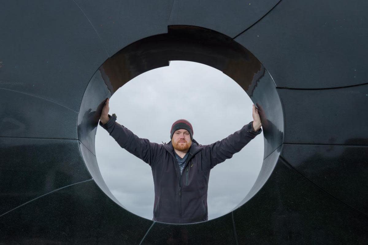 University of Sunderland engineering student John Race at the 'C' sculpture on Roker seafront, commemorating the place where the Venerable Bede calculated the motion of the sun and the moon to help set the date of Easter <i>(Image: UNIVERSITY OF SUNDERLAND)</i>