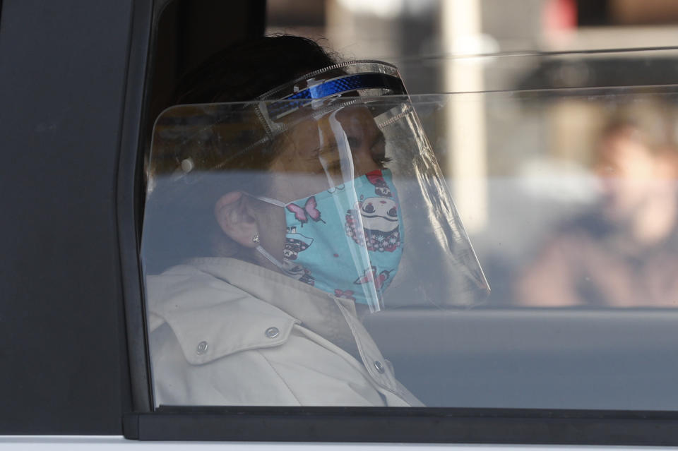 A passenger wearing a mask and face shield as a precaution against the spread of the new coronavirus, looks from the window of a taxi in La Paz, Bolivia, Monday, June 1, 2020. After more than two months of quarantine, the government approved the reopening of some commercial activity and public transport, as the total lockdown begins to ease,. (AP Photo/Juan Karita)