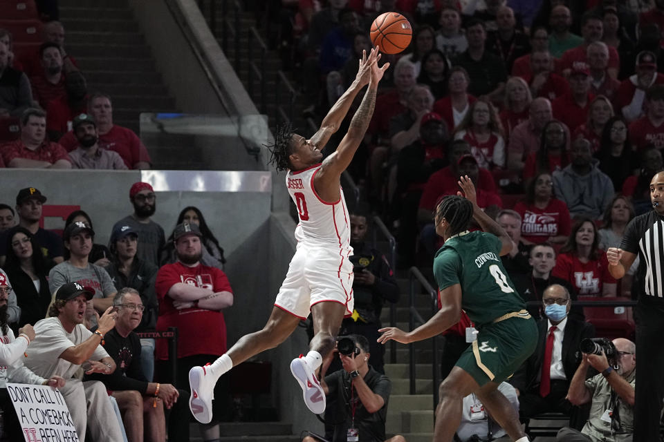 Houston's Marcus Sasser, left, shoots after being fouled by South Florida's Ryan Conwell, right, during the second half of an NCAA college basketball game Wednesday, Jan. 11, 2023, in Houston. Houston won 83-77. (AP Photo/David J. Phillip)