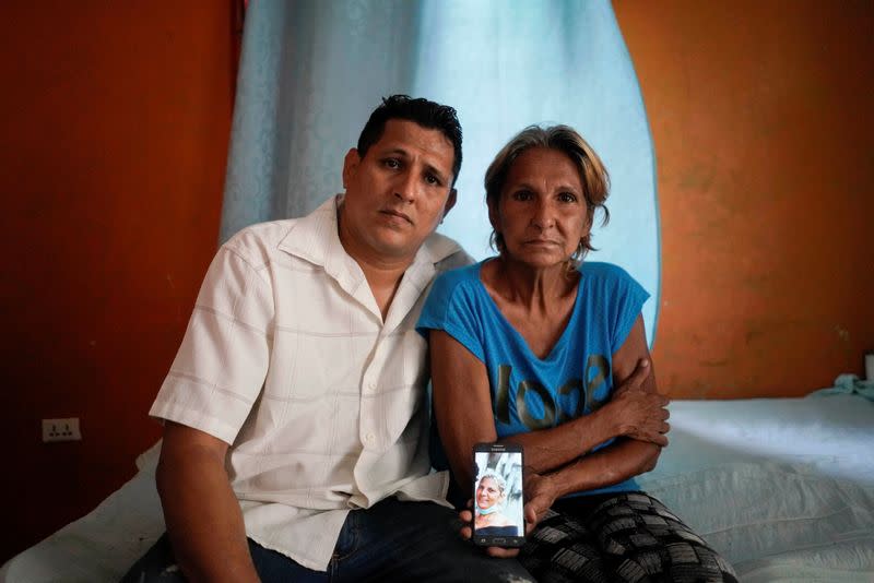 Alberto Betancourt y su madre Mayra Pérez posan con la foto de su hermana e hija, Daylin Betancourt, detenida por la policía durante una protesta, en La Habana, Cuba.