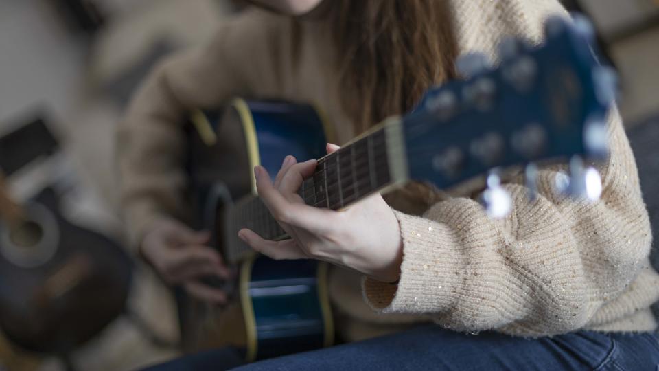 Woman fretting guitar