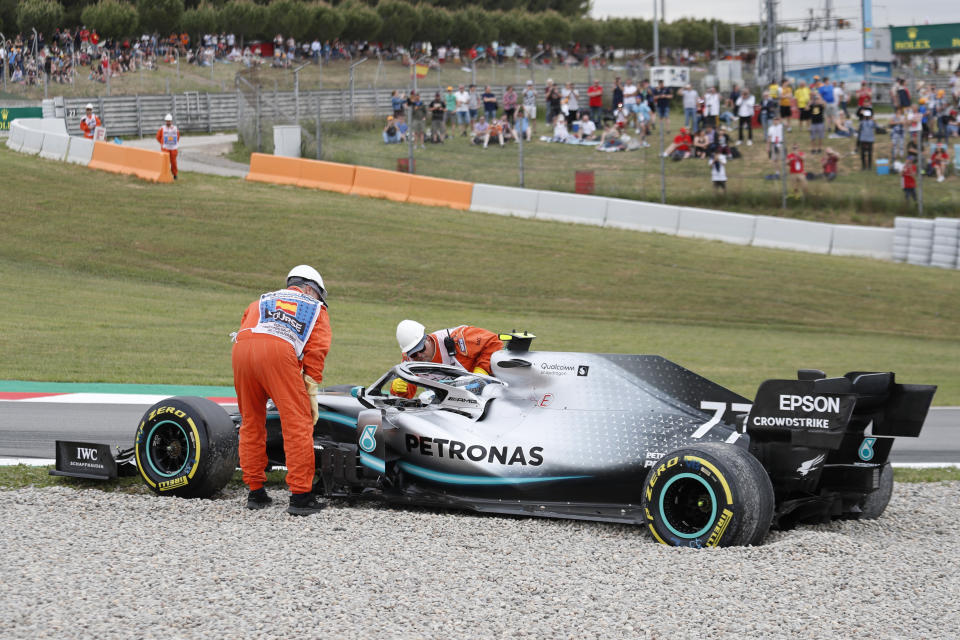 Track marshals check on Mercedes driver Valtteri Bottas of Finland after he skidded off the track into the gravel during free practice at the Barcelona Catalunya racetrack in Montmelo, just outside Barcelona, Spain, Saturday, May 11, 2019. The Spanish F1 Grand Prix race will be held on Sunday. (AP Photo/Joan Monfort)