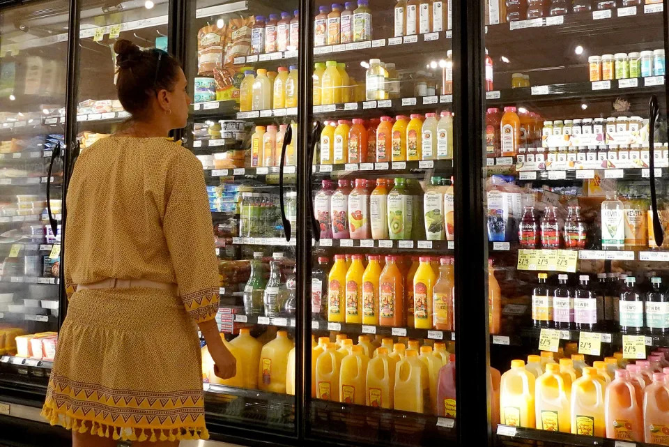 A woman looks at bottle of juice. (Joe Raedle / Getty Images file)