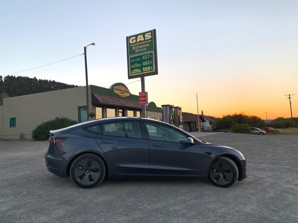 The Tesla parked in front of a gas station.