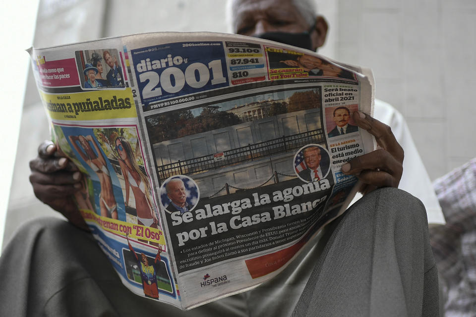 FILE - In this Nov. 4, 2020, a man reads the Diario 2001 newspaper that carries the Spanish headline: "Agony is prolonged for the White House" at a newspaper stand in Caracas, Venezuela, the day after U.S. elections. Across the world, many were scratching their heads Friday wondering if those assertions could truly be coming from the president of the United States, the nation considered one of the world’s most emblematic democracies. (AP Photo/Matias Delacroix, File)