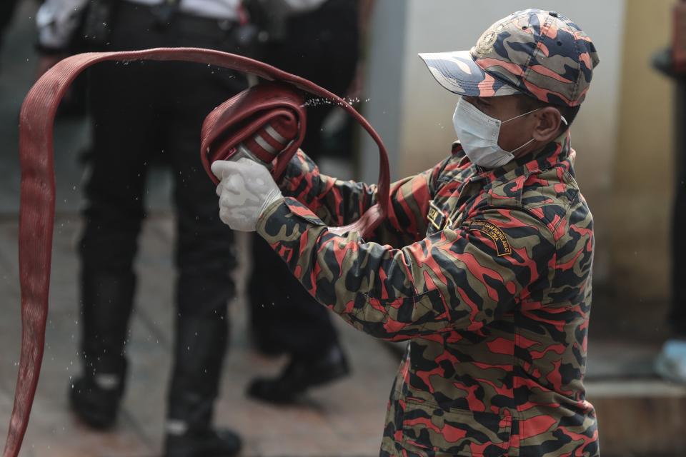 <p>A Fire and Rescue Department officer rolls a fire hose after a fire broke out at a religious school in Jalan Datuk Keramat, Kuala Lumpur, Malaysia, Sept. 14, 2017. (Photo: Fazry Ismail/EPA-EFE/REX/Shutterstock) </p>