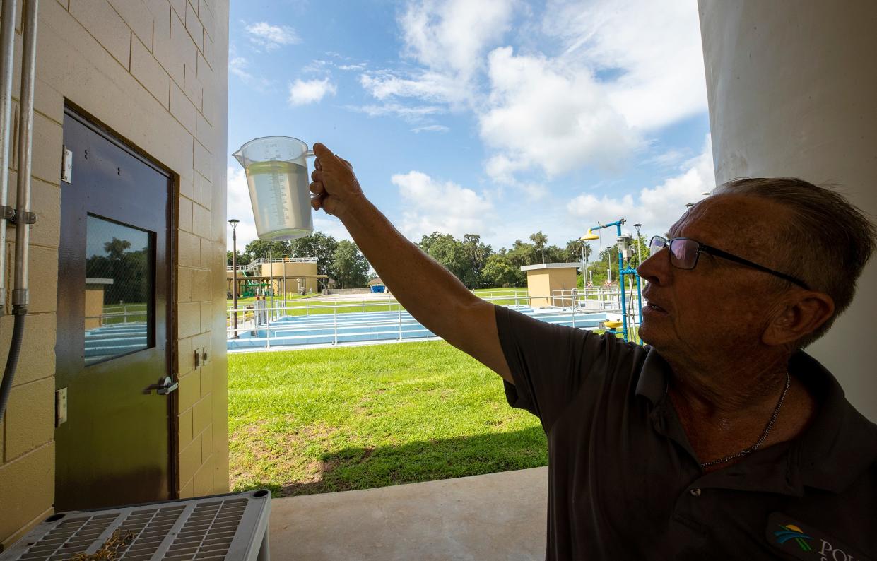 Howard Coggin, a water pollution operator for Polk County Utilities, holds a container of final treated water at the Northwest Wastewater Treatment Facility on North Campbell Road in Lakeland on Thursday July 8 2021.