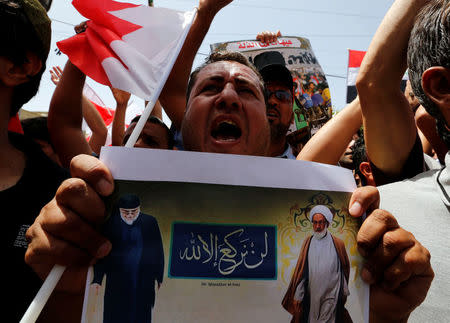 REFILE - ADDING RESTRICTION Supporters of Iraqi Shi'ite cleric Moqtada al-Sadr hold poster of Shi'ite cleric Ayatollah Sheikh Isa Qassim (R) during a demonstration in front of the Bahraini embassy in Baghdad, Iraq May 24, 2017. REUTERS/Wissm al-Okili