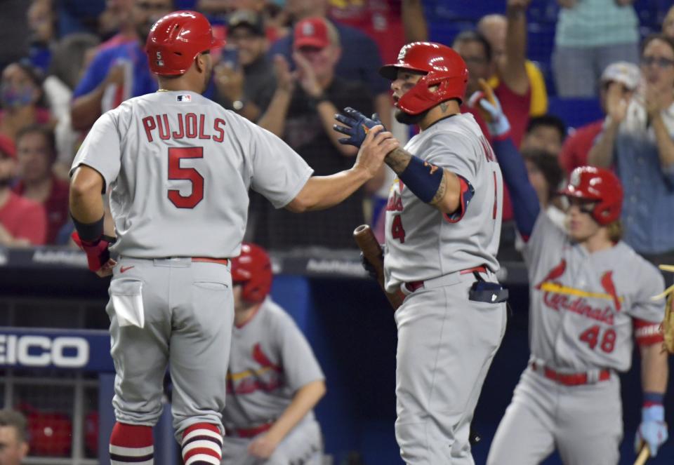 Albert Pujols is greeted by St. Louis teammate Yadier Molina after scoring during the second inning of Tuesday's night 5-1 win over Miami.