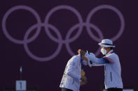 First placed South Korea's An San, left, and South Korea's Kim Je Deok receive the gold medals on the podium of a mixed team competition at the 2020 Summer Olympics, Saturday, July 24, 2021, in Tokyo, Japan. (AP Photo/Alessandra Tarantino)