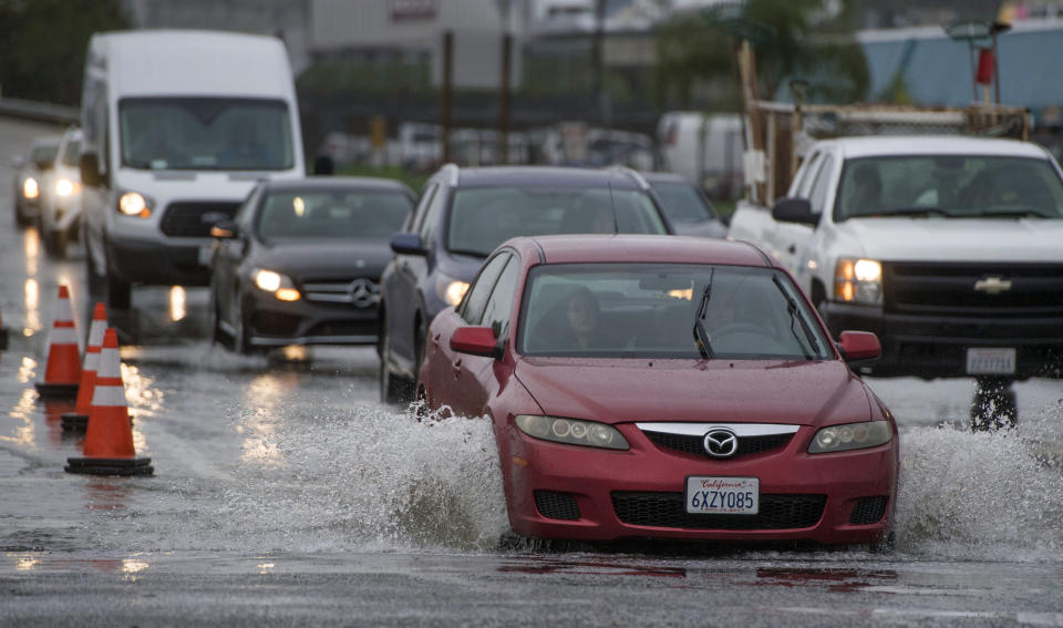 Cars go through a deep puddle at the Garden Grove (22) Freeway exits at Haster Street in Garden Grove, Calif., Friday, Jan. 20, 2017. (Jeff Gritchen/The Orange County Register via AP)