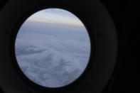 The frozen tundra of northern Alaska is seen out a window of an Alaska National Guard cargo plane en route to Nuiqsut, Alaska, on Tuesday, Nov. 29, 2022. Operation Santa Claus, the Alaska National Guard's outreach program, attempts to bring Santa and Mrs. Claus and gifts to children in two or three Alaska Native villages each year, including Nuiqsut in 2022. (AP Photo/Mark Thiessen)