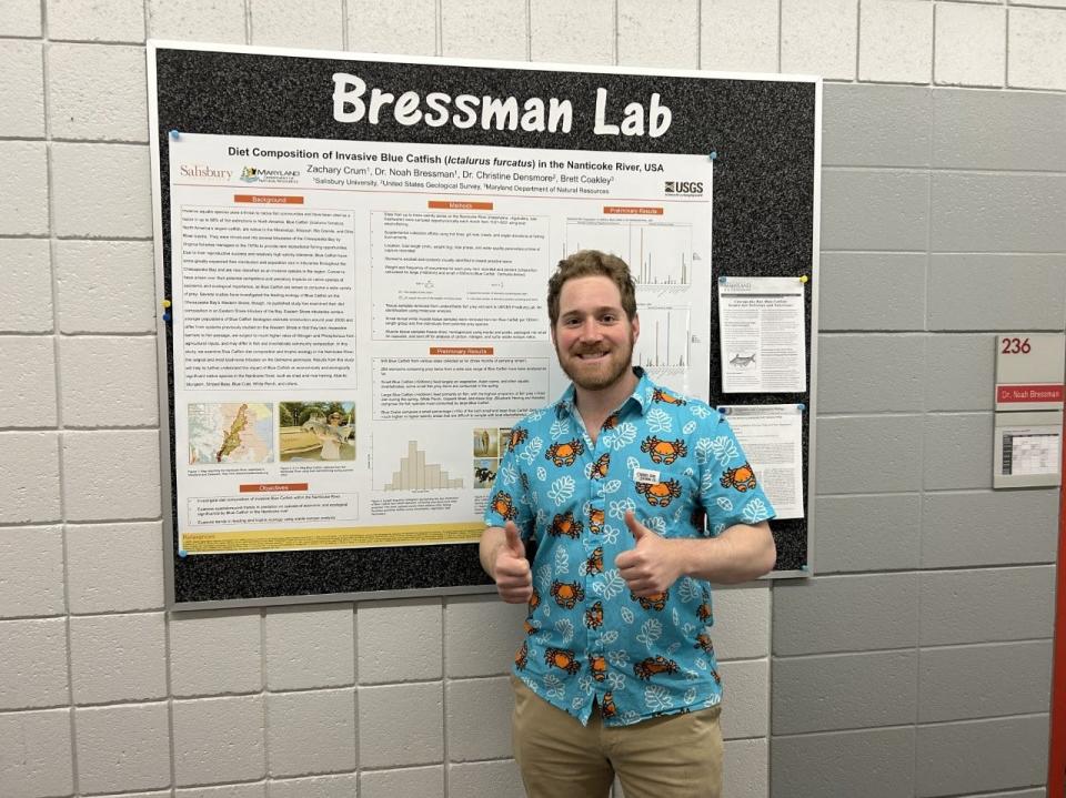 Noah Bressman, an assistant professor in the Biology Department at Salisbury University, stands in front of research showing the diet composition of invasive blue catfish. Bressman said the species eats "anything and everything they can get their mouths around," including blue crab, muskrats, and ducks.