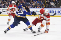 Calgary Flames defenseman Erik Gudbranson (44) is hit by St. Louis Blues left wing David Perron's (57) stick during the second period of an NHL hockey game Thursday, Jan. 27, 2022, in St. Louis. (AP Photo/Joe Puetz)