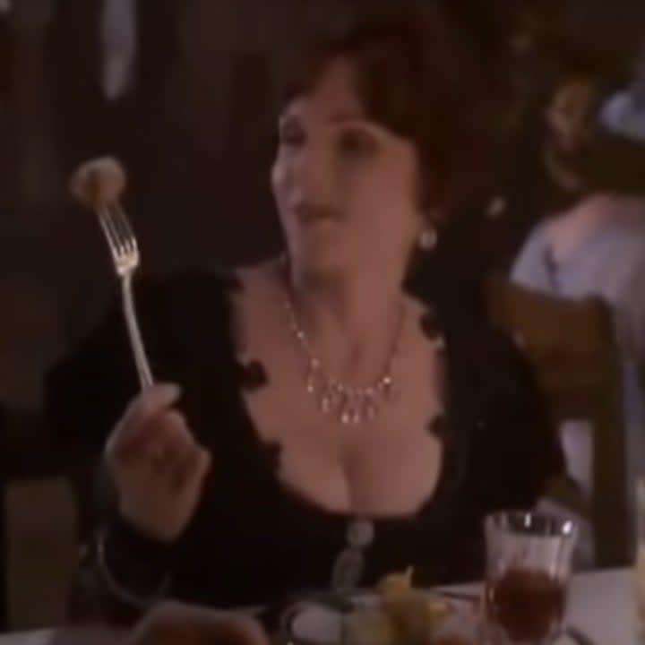 A woman wears a black dress at a fancy dinner in the Titanic miniseries