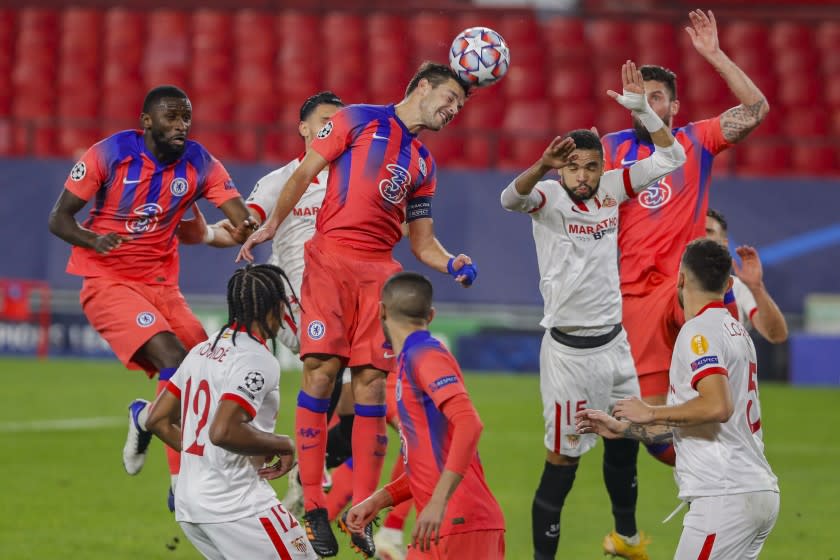 Chelsea's Cesar Azpilicueta, center, heads for the ball during the Champions League group E soccer match between Sevilla and Chelsea at the Ramon Sanchez Pijuan stadium in Seville, Spain, Wednesday, Dec. 2, 2020. (AP Photo/Angel Fernandez)