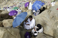 A Muslim pilgrim couple prays on the rocky hill known as the Mountain of Mercy on the Plain of Arafat during the annual hajj pilgrimage, near the holy city of Mecca, Saudi Arabia, Monday, July 19, 2021. The coronavirus has taken its toll on the hajj for a second year running. What once drew some 2.5 million Muslims from all walks of life from across the globe, the hajj pilgrimage is now almost unrecognizable in scale. (AP Photo/Amr Nabil)