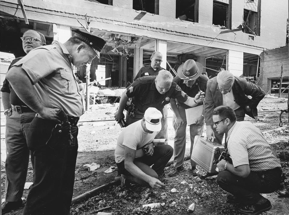 FILE - In this August, 1970, file photo officials look for clues after a bomb exploded outside the Army Mathematics Research Center in Sterling Hall at the University of Wisconsin in Madison. Forty years after after the Aug. 24, 1970 explosion that killed one, injured others and caused millions in damage, Leo Burt remains the last fugitive wanted by the FBI in connection with radical anti-Vietnam War protest activities. (Ed Stein/Wisconsin State Journal via AP, File)