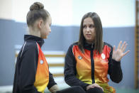 Sara Becarevic, left, listens to her coach Amina Lepic Mlivic, during a training session, in Visoko, Bosnia, Wednesday, Dec. 1, 2021. In Bosnia, a poor, Balkan country which habitually marginalizes people with disabilities, a soon-to-be-14-year-old girl, born without her lower left arm, pursues her dream of becoming an internationally recognized rhythmic gymnast. Sara Becarevic says she got enchanted with the demanding sport as a toddler, while watching the world championships on television. (AP Photo)