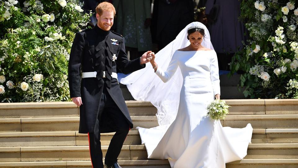 Prince Harry holds Meghan Markles hand as they walk down the stairs at Georges Chapel where they just got married at Windsor Castle