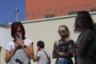 Friends and relatives of those detained during mass rally following presidential election gather at a detention center in Minsk, Belarus, Tuesday, Aug. 11, 2020. The Belarusian Interior Ministry said Tuesday that more than 2,000 people were detained across the country for taking part in unsanctioned protests on Monday evening and overnight. It added that 21 police officers were injured in clashes with protesters, and five of them were hospitalized. (AP Photo/Sergei Grits)