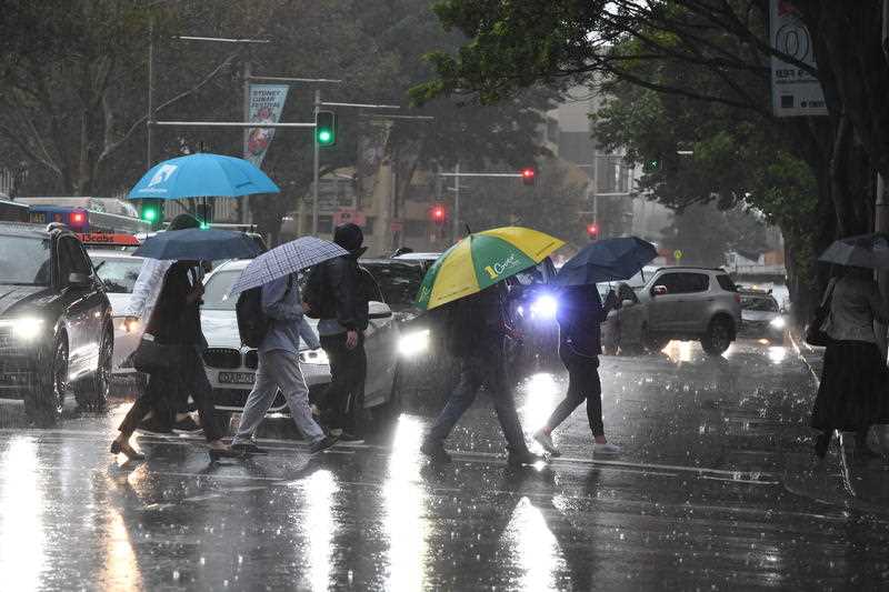 Pedestrians hold umbrellas during wet weather in Sydney.