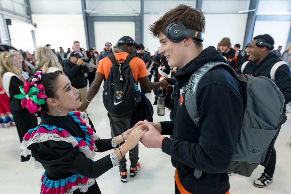 Oregon State football players dance with Folklorico dancers as they arrive in El Paso on Monday, Dec. 25, 2023, for the Tony the Tiger Sun Bowl.