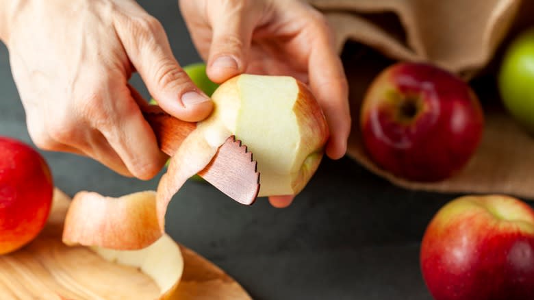 peeling an apple over cutting board