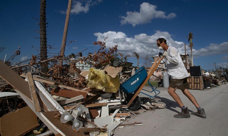 Mike Boyce helps remove debris from the home of a family member in St. James City, Monday, Nov. 7, 2022. While enormous clean-up efforts in Pine Island persisted throughout the past month, debris piles continued to be a visible reminder of the magnitude of Hurricane Ian's impact to the area.