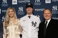 New York Yankees' Gerrit Cole, center, joined by his wife Amy, left, and agent Scott Boras, is introduced as the baseball club's newest player during a media availability, Wednesday, Dec. 18, 2019 in New York. The pitcher agreed to a 9-year, $324 million contract. (AP Photo/Mark Lennihan)