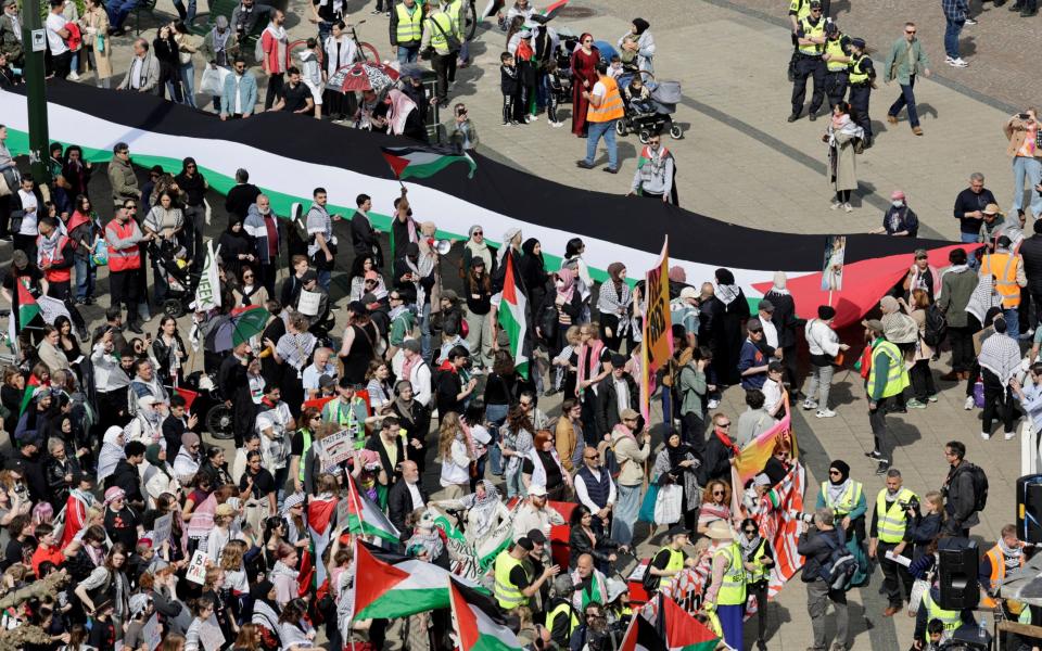 Protesters unfurl a Palestinian flag