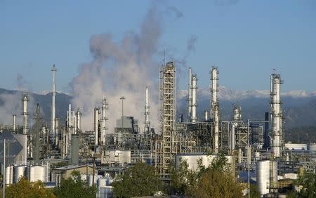 An oil refinery is seen with the Rocky Mountains freshly covered with snow in the background in Denver October 14, 2014. REUTERS/Rick Wilking/Files