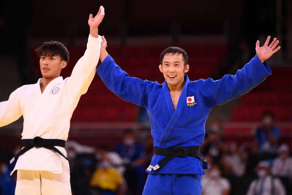 Japan's Naohisa Takato (R) celebrates winning the judo men's 60kg