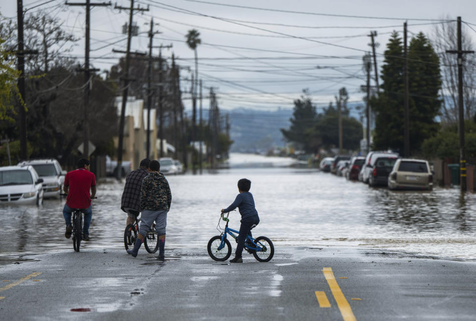 People look at heavy floodwaters in Watsonville, Calif., Saturday, March 11, 2023. Gov. Gavin Newsom has declared emergencies in 34 counties in recent weeks, and the Biden administration approved a presidential disaster declaration for some on Friday morning, a move that will bring more federal assistance. (AP Photo/Nic Coury)