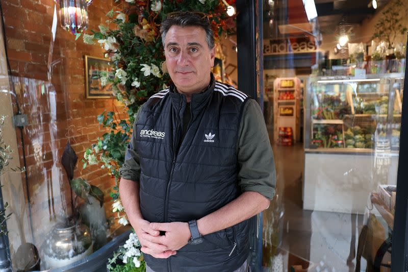 Andreas Georghiou poses for a portrait at his grocery store, in London