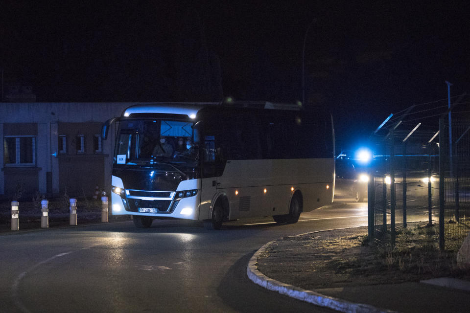 A bus carrying French citizens returning from the virus-hit city of Wuhan arrives in Aix-en-Provence, southern France, Sunday, Feb. 2, 2020. A second French-chartered plane carrying 300 evacuees from China flew to France on Sunday as more foreigners fled China's rapidly developing virus. (AP Photo/Daniel Cole)