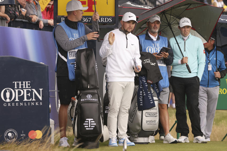 England's Matt Fitzpatrick, right with his brother Alex Fitzpatrick wait under umbrellas to play on the 4th tee box during a practice round for the British Open Golf Championships at the Royal Liverpool Golf Club in Hoylake, England, Monday, July 17, 2023. The Open starts Thursday, July 20. (AP Photo/Peter Morrison)